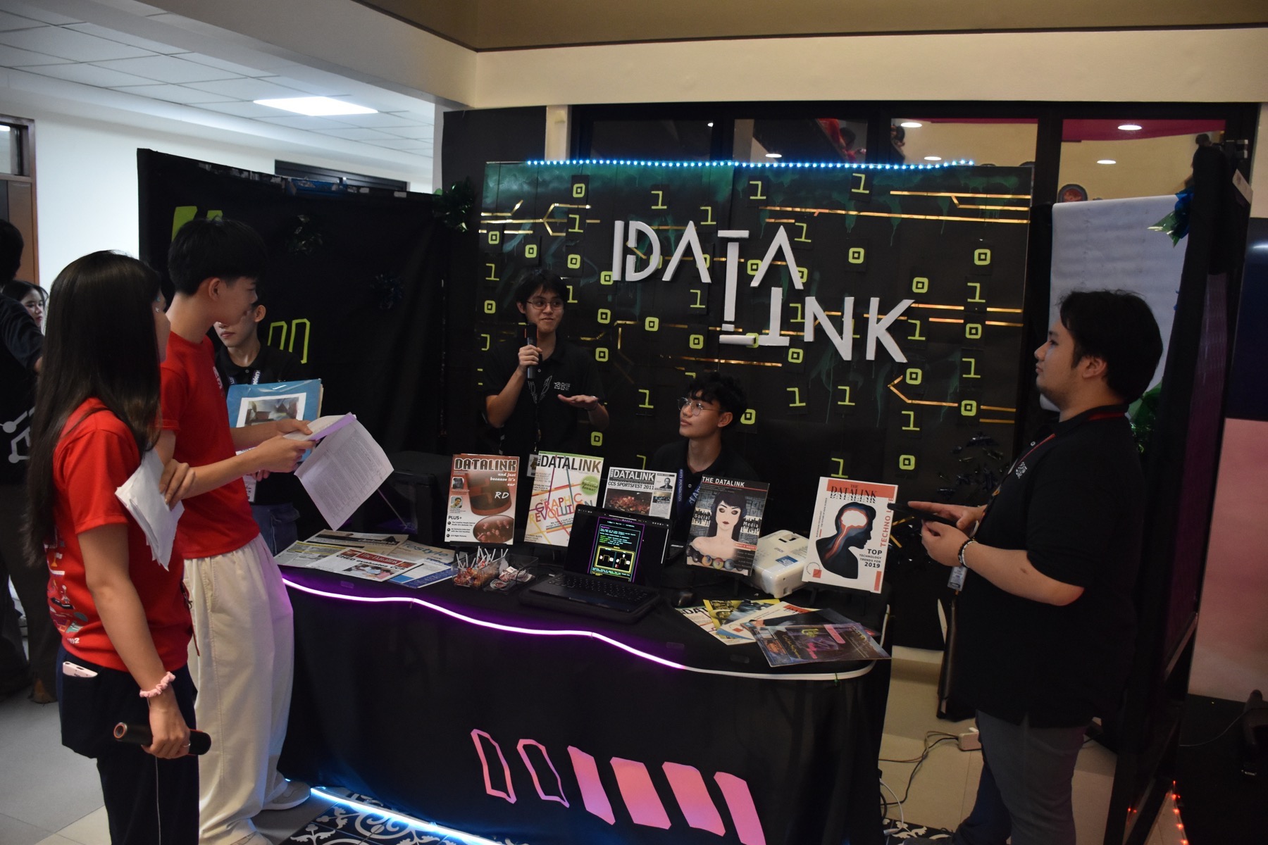 Datalink booth presentation with printed materials and neon display